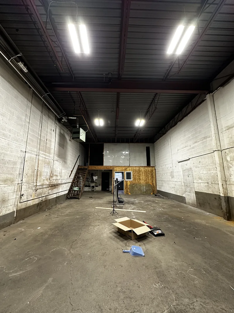 Bare commercial unit before fit-out: exposed block walls and concrete floor
