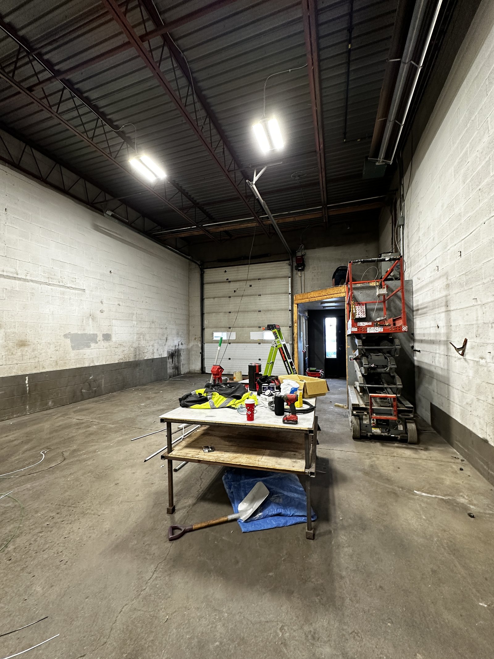 Commercial unit stripped back during fit-out, with bare block walls and services exposed