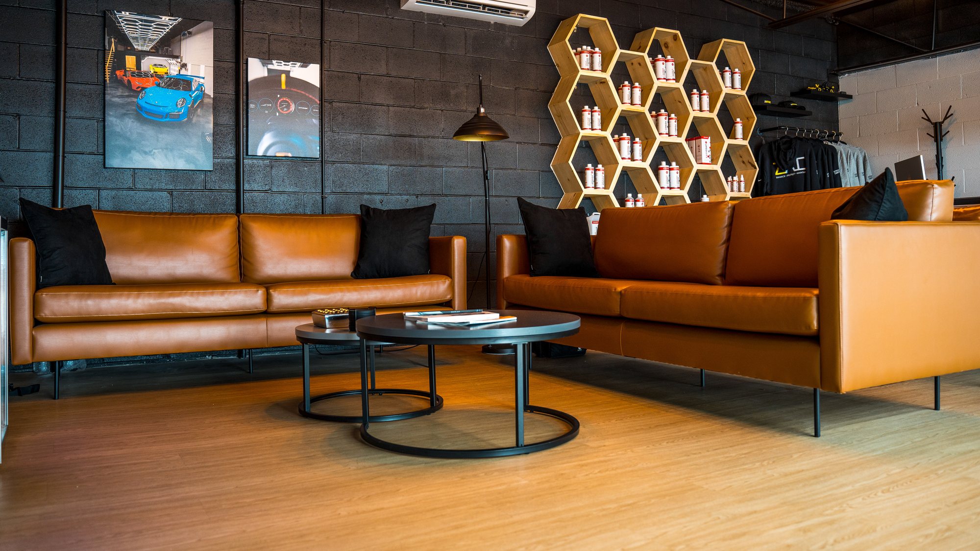 Waiting lounge with tan leather seating, timber flooring and framed wall art
