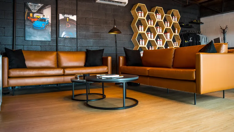Waiting lounge with tan leather seating, timber flooring and framed wall art