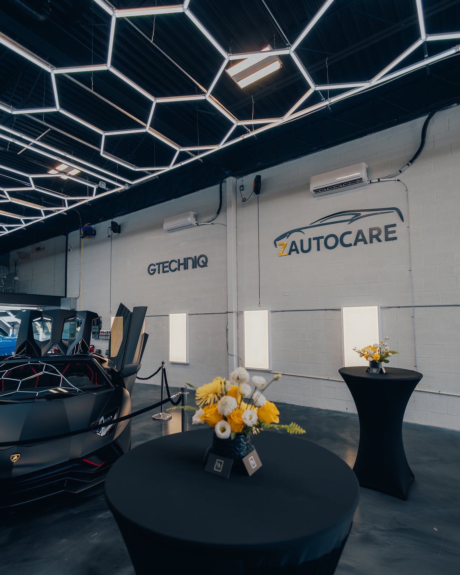 Commercial automotive showroom with hexagon ceiling lighting and polished concrete floors