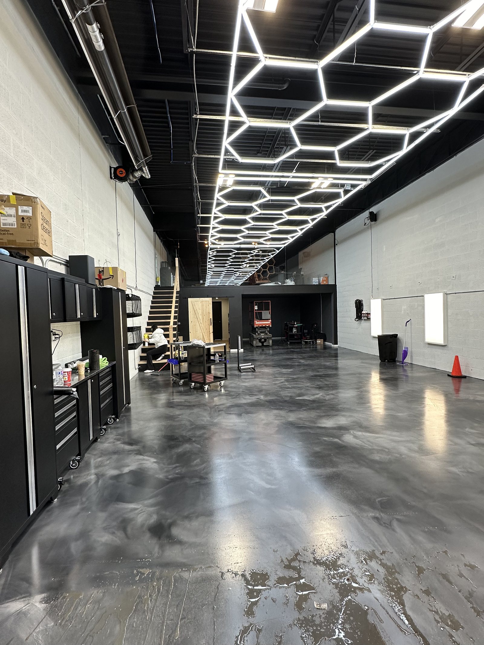 Commercial workshop with hexagon LED lighting, black cabinetry and polished floors