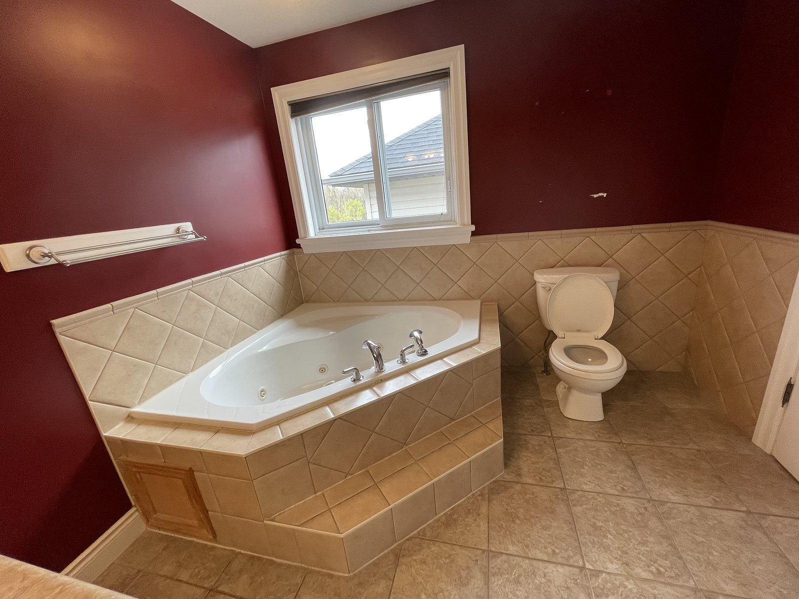 Bathroom before renovation: beige tile, corner jetted tub and dated fixtures