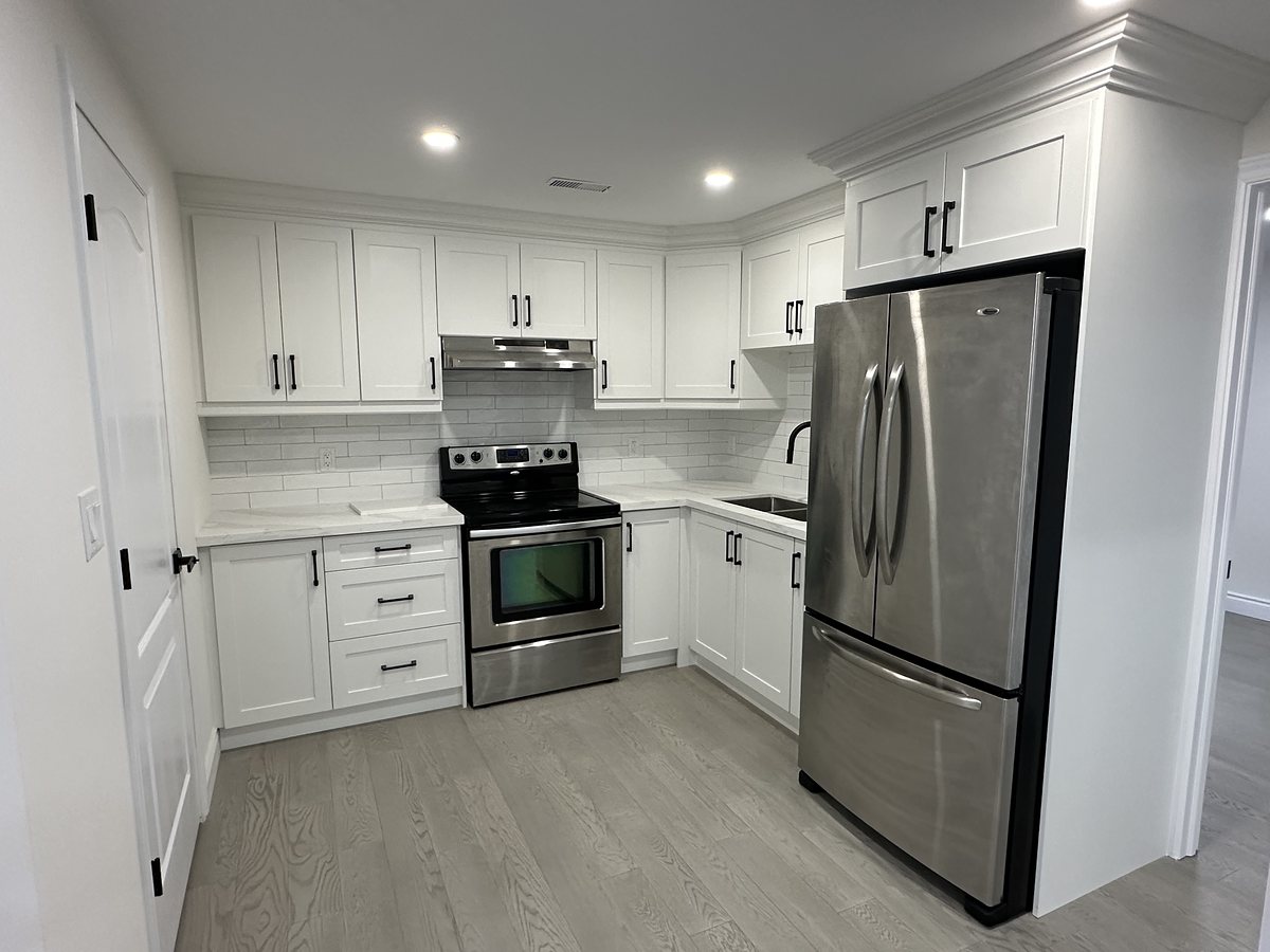 Renovated galley kitchen with white cabinetry and stainless appliances