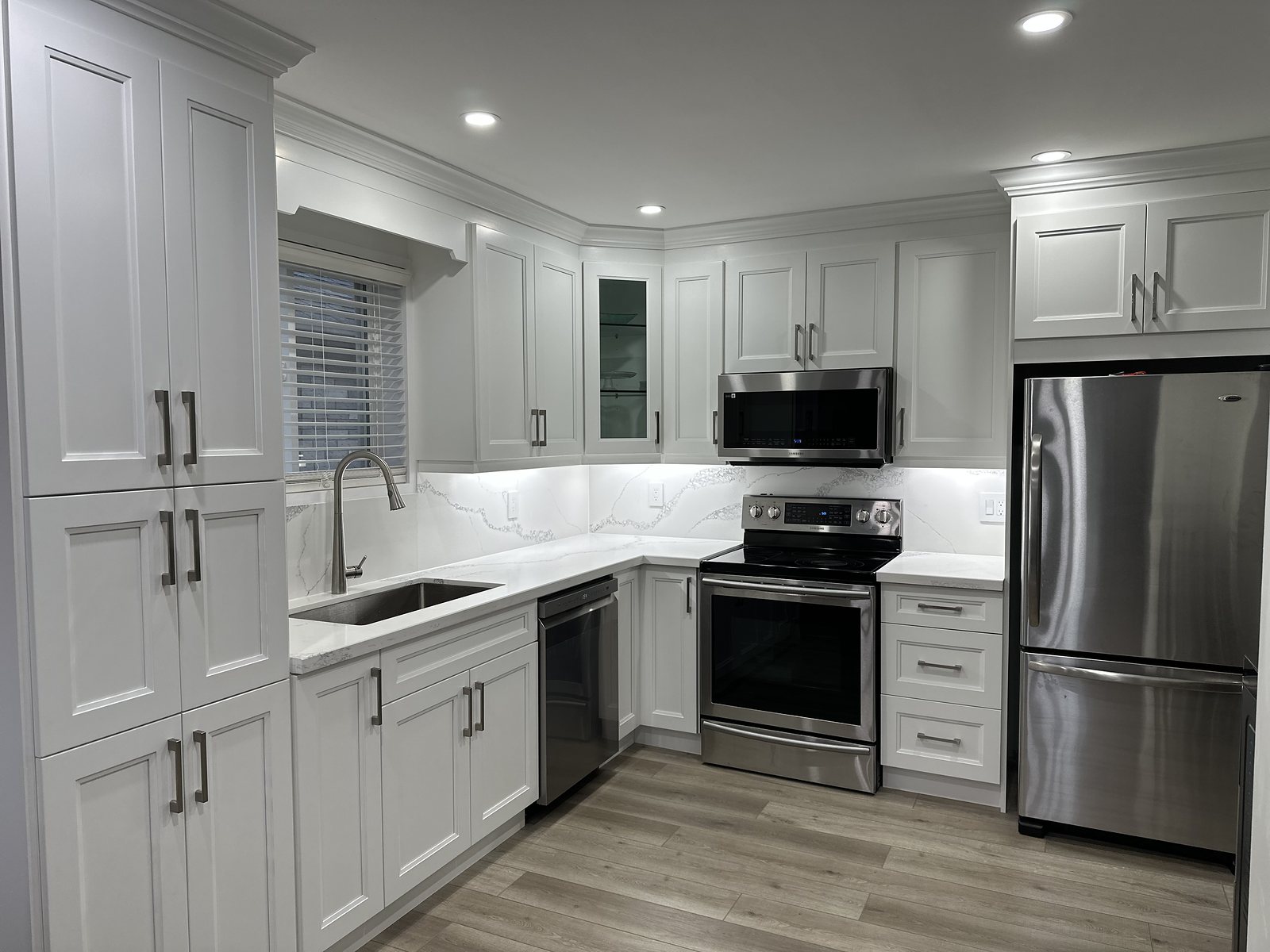 Renovated kitchen with white shaker cabinetry, quartz counters and stainless appliances