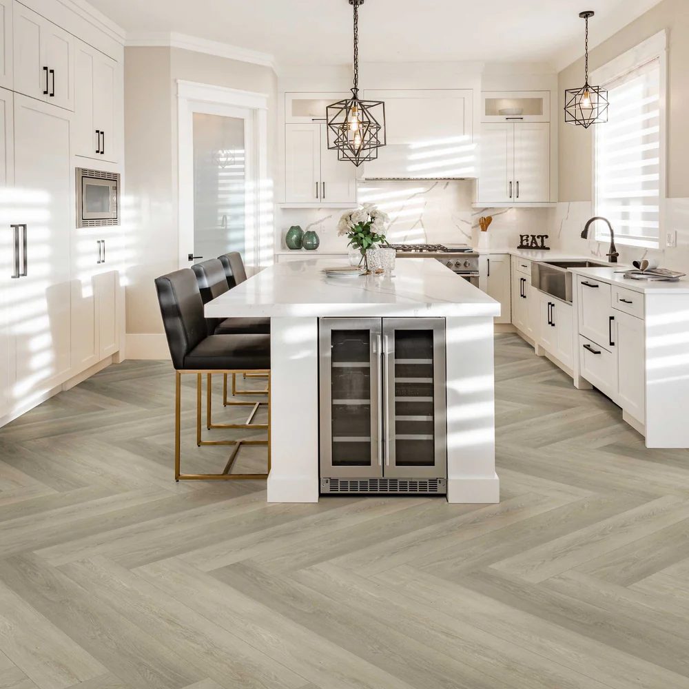 Herringbone-pattern wood-look flooring running through an open-plan kitchen