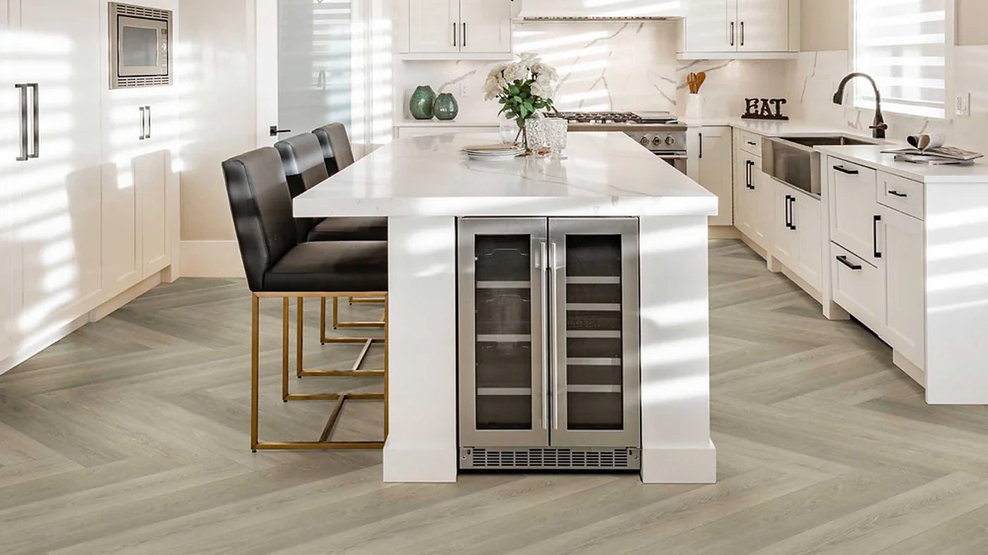 Herringbone-pattern wood-look flooring running through an open-plan kitchen