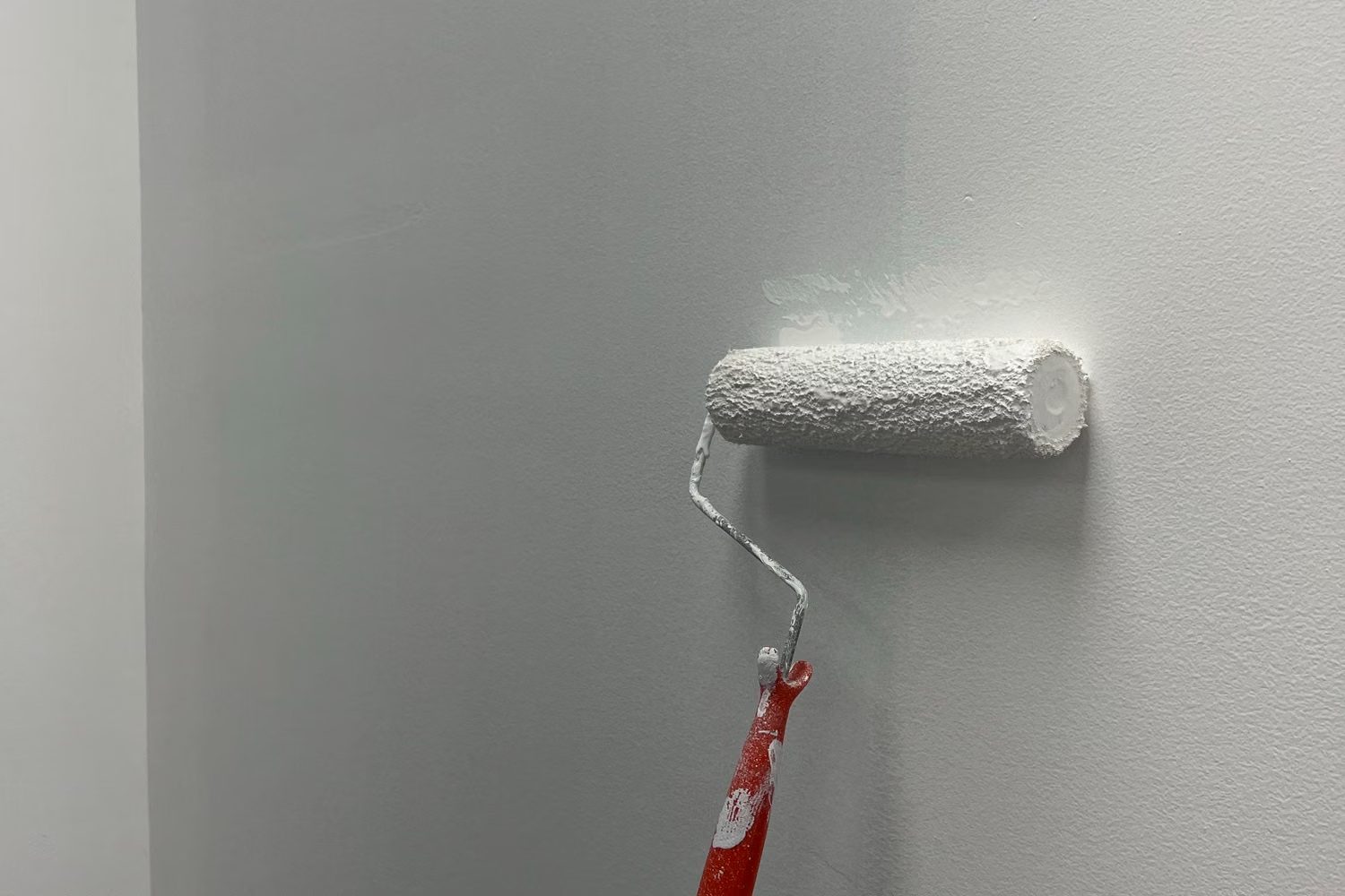 Paint roller applying a smooth even coat to an interior wall