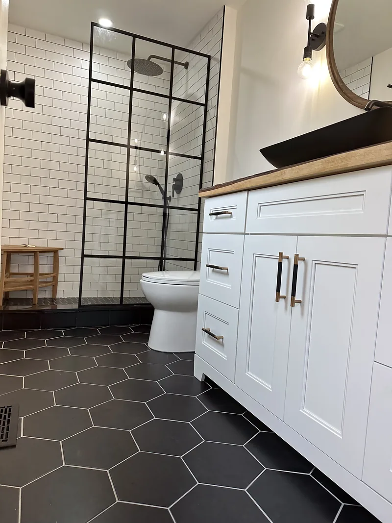 Completed Westvale bathroom with black hexagon floor tile and white subway walls